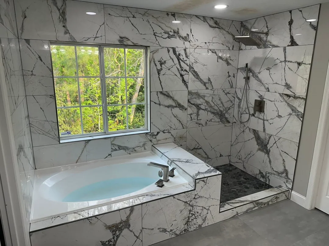 Finished calacatta marble tub surround and walk-in shower by KV Tileworks